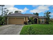 Charming single-story home with a well-manicured lawn and an attached two-car garage at 17215 Berwin Ave, Port Charlotte, FL 33948