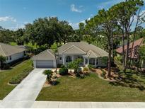 Well-maintained home with mature landscaping, tile roof, and a two-car garage on a sunny day at 2016 White Feather Ln, Nokomis, FL 34275
