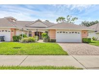 Charming single-story home featuring a well-manicured lawn and a two-car garage with a brick driveway at 2025 Lynx Run, North Port, FL 34288