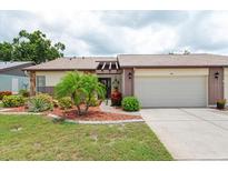 Charming single-story home with a well-manicured lawn and an attached two-car garage at 204 Aspen St, Englewood, FL 34223