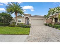 Charming single-story home featuring a lush green lawn, beautiful landscaping, and a paver driveway at 2920 Oriole Dr, Sarasota, FL 34243