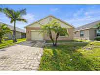 Charming single-story home with a brick paver driveway and well-maintained lawn with two palm trees in front yard at 3362 Howell Pl, Sarasota, FL 34232