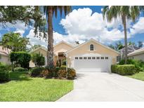 Charming single-story home with a well-manicured lawn, mature trees, and a two-car garage at 4374 Mirabella Cir, Bradenton, FL 34210