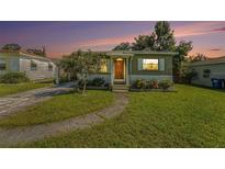 Charming single-story home with well-maintained lawn, mature tree, and inviting front entrance at 5028 Oxford N Ave, St Petersburg, FL 33710