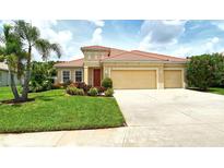 Charming single-story home featuring a red tile roof, well-manicured lawn, and a two-car garage at 6214 45Th E Ln, Bradenton, FL 34203