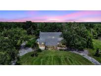 Charming two-story home featuring a stone foundation and inviting covered porch, surrounded by lush greenery at 6633 Old Ranch Rd, Sarasota, FL 34241