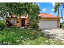 Charming one-story home with a red roof, arched windows, and a spacious two car garage at 6805 225Th E St, Bradenton, FL 34211