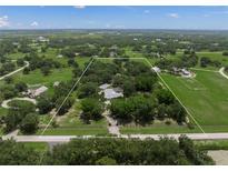 Expansive property featuring a lush green landscape with mature trees and a charming home, fully fenced at 7343 Palomino Trl, Sarasota, FL 34241