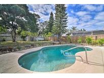 A refreshing swimming pool with a backyard surrounded by lush greenery and a well-maintained fence at 7511 1St W Ave, Bradenton, FL 34209