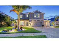 Stunning two-story home featuring a well-manicured lawn, a three-car garage, and a welcoming front porch at 7915 115Th E Ave, Parrish, FL 34219