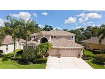 Beautiful two-story home with a three-car garage and tropical landscaping at 7915 Kavanagh Ct, Sarasota, FL 34240