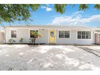 Charming single-story home with a bright yellow door, well-kept landscaping, and a gravel driveway at 111 66Th Street E Ct, Bradenton, FL 34208