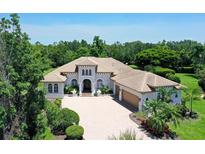 Stunning home featuring a tile roof, three car garage, and beautiful landscaping at 13203 Lost Key Pl, Lakewood Ranch, FL 34202