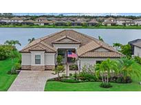Beautiful single-Gathering home with a gorgeous yard, landscaping, and a glimpse of the serene lake in the background at 17320 Polo Trl, Bradenton, FL 34211