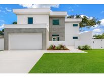 Modern two-story home featuring a clean white facade, gray accents, and a well-manicured lawn at 2065 Goldenrod St, Sarasota, FL 34239