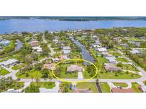 Aerial view of a charming home with a well-manicured lawn and water access via a canal in a waterfront community at 336 Highland Shores Dr, Ellenton, FL 34222