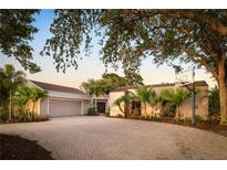 Lovely home featuring a brick driveway, basketball hoop and lush, tropical landscaping at 3658 Torrey Pines Way, Sarasota, FL 34238