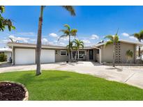 Charming single-story home featuring a well-manicured lawn, palm trees, and a spacious driveway at 3715 Bamboo Ter, Bradenton, FL 34210