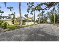 Charming yellow cottage-style home featuring a screened porch and well-maintained landscaping at 403 29Th Nw St, Bradenton, FL 34205