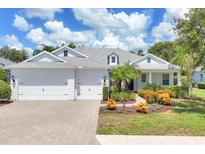 Charming single-story home with a well-manicured lawn, colorful flower beds, and a three-car garage at 4714 Seneca Park Trl, Bradenton, FL 34211
