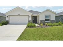Charming one-story home with a well-manicured lawn, a two-car garage, and stone accents at 6528 166Th E Pl, Parrish, FL 34219
