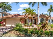 Beautifully landscaped single-Gathering home featuring a clay tile roof and attached two-car garage at 7521 Aralia Way, Seminole, FL 33777
