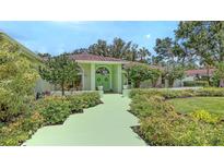 Charming home featuring a colorful entryway, lush landscaping, and a well-maintained front yard at 7604 Weeping Willow Cir, Sarasota, FL 34241