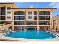 Stunning condominium building featuring a beautiful blue swimming pool with lounge chairs and ample patio seating at 8750 Midnight Pass Rd # 501, Sarasota, FL 34242