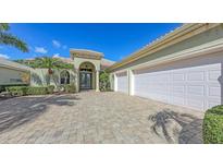 Elegant home featuring a three-car garage and lush landscaping at 8832 Enclave Ct, Sarasota, FL 34238