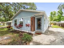 Charming light blue home featuring a landscaped yard and inviting front door with vertical wood accent at 1008 37Th W St, Bradenton, FL 34205