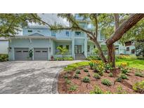 A bright, light blue two-story home with a paver driveway and an oversized 2-car garage at 1076 Toc0Baga, Sarasota, FL 34234