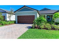 Charming home featuring a spacious two-car garage, well-manicured lawn, and a welcoming facade at 12827 Lily Quartz Loop, Parrish, FL 34219