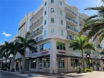 Beautiful condos with black metal railings, balconies, and a glimpse of vibrant palm trees on a sunny day at 1500 State St # 505, Sarasota, FL 34236
