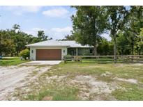 Charming single-story home featuring a metal roof and well-maintained front yard with a wooden fence at 15780 Wilson Rd, Sarasota, FL 34240