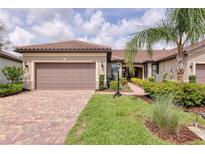 Charming single-story home featuring a tile roof, two-car garage, and lush landscaping at 17648 Northwood Pl, Lakewood Ranch, FL 34202