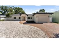 Charming single story home featuring a brick driveway, manicured landscaping, and attached garage at 1881 Orchid St, Sarasota, FL 34239