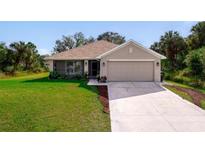 Charming single-story home featuring a well-manicured lawn, a two-car garage, and a screened front porch at 3524 Brownwood Ter, North Port, FL 34286