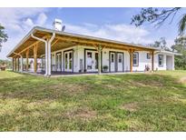 Sprawling ranch-style house features a beautiful covered porch and well-maintained lawn at 39700 State Road 70 E, Myakka City, FL 34251