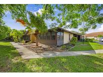 Charming corner home featuring a landscaped yard, mature trees, and a screened-in porch for relaxing outdoors at 4153 66Th Street W Cir # 4153, Bradenton, FL 34209