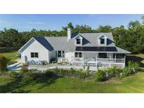 Inviting two-story home featuring a charming front porch and lush, landscaped surroundings at 4888 Old Ranch Rd, Sarasota, FL 34241