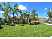 Charming tan home with lush green lawn and mature palm trees under a bright blue sky at 5080 Timber Chase Way, Sarasota, FL 34238