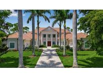 Elegant home featuring manicured lawn, brick walkway, and stately columns leading to the inviting front entrance at 550 Dove Pointe, Osprey, FL 34229
