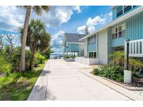 Inviting waterfront condo featuring a private walkway and a calming light blue exterior at 6005 N Beach Rd # 16, Englewood, FL 34223