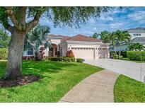 Charming home featuring a three-car garage, beautiful landscaping, and well-manicured lawn at 6610 Rosy Barb Ct, Lakewood Ranch, FL 34202