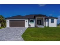 Modern single-story home featuring a stone driveway, manicured lawn, and a two-car garage at 8045 Bosco Rd, Port Charlotte, FL 33981
