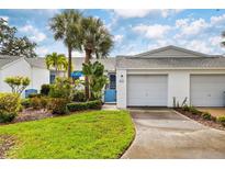 Charming villa with a two-car garage, mature palm trees, and a well-manicured lawn at 805 Waterside Ln, Bradenton, FL 34209