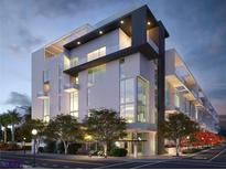 Modern condo building featuring multiple levels and large windows with attractive landscaping at 1305 4Th St # 301G, Sarasota, FL 34236