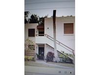 Inviting two-story condo with stairs leading to the entrance and well-maintained landscaping at 137 Pineneedle Dr # 137, Bradenton, FL 34210