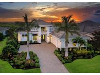 Elegant two-story home featuring a beautiful stone driveway, manicured landscaping, and a welcoming front entrance at 16917 Clearlake Ave, Lakewood Ranch, FL 34202