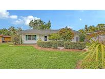 Charming home featuring lush lawn, verdant hedges, and well-maintained landscaping at 2088 Grove St, Sarasota, FL 34239